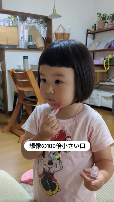 リップを口もとに持って行く女の子