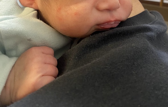 げっぷによりおじいちゃんのような顔になった赤ちゃんの口元