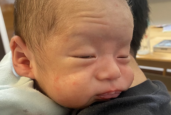 げっぷによりおじいちゃんのような顔になった赤ちゃん