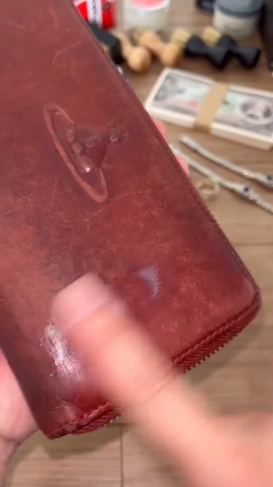 中古のヴィヴィアン・ウエストウッドの財布に皮革用のクリームを塗っていく