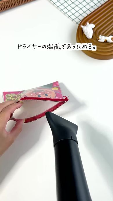 口を広げたカードケースをドライヤーであたためる