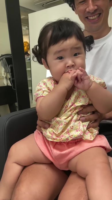 前髪をカットしてかわいく仕上げてもらったことを感謝するかのように声を上げる赤ちゃん