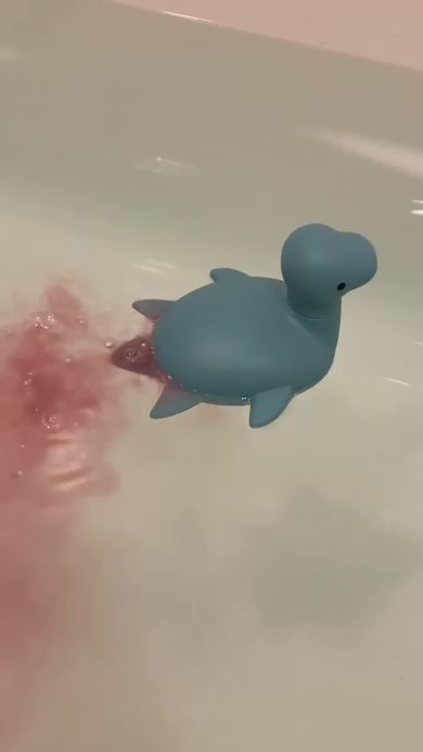 赤色の炭酸入浴剤を入れたため負傷したように見えるプレシオサウルスのおもちゃ