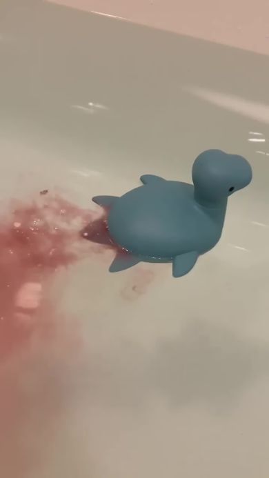 赤色の炭酸入浴剤を入れたため負傷したように見えるプレシオサウルスのおもちゃ