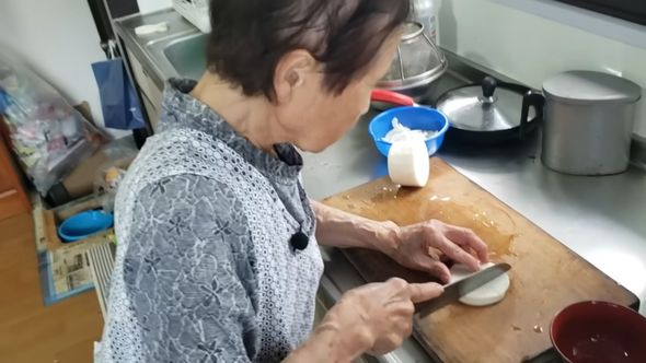 包丁をしっかり握って大根を切る92歳の祖母
