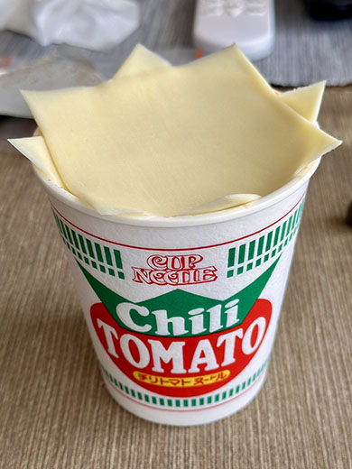 チリトマトヌードルをチーズでふたをしているところ