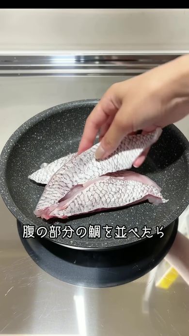 アクアパッツァを作るため鍋に切り出したタイの腹部を並べる