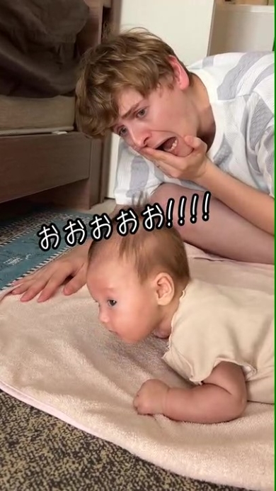 赤ちゃんに声をかけるパパ