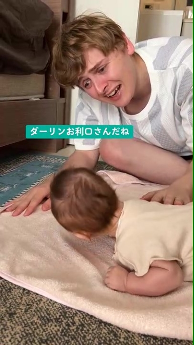 赤ちゃんに声をかけるパパ