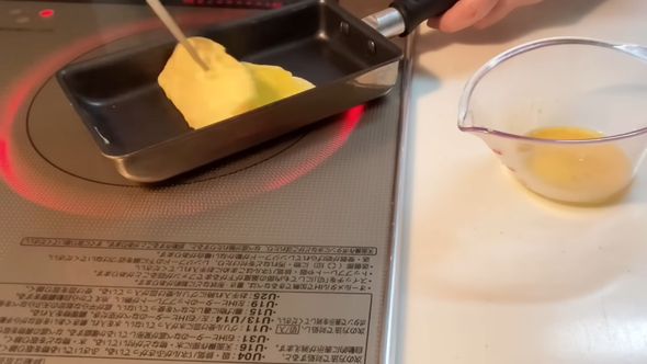 理想のお弁当箱に詰める卵焼きを作る様子