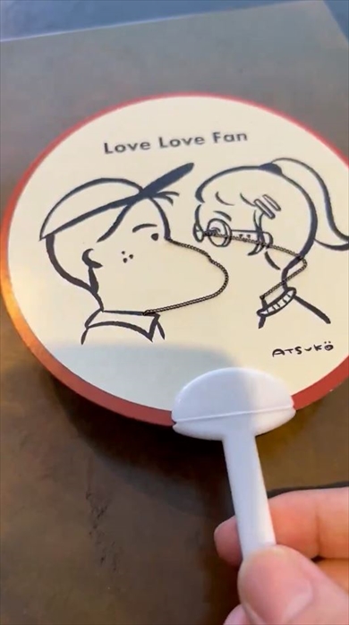 男女がキスするうちわ