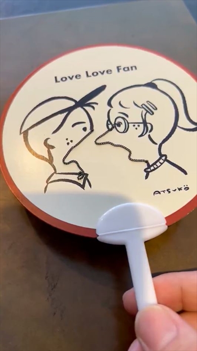男女がキスするうちわ