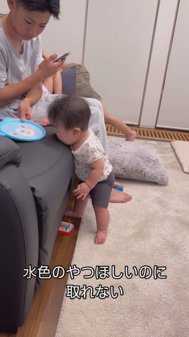 ソファの上のものが取れなくて泣く赤ちゃん