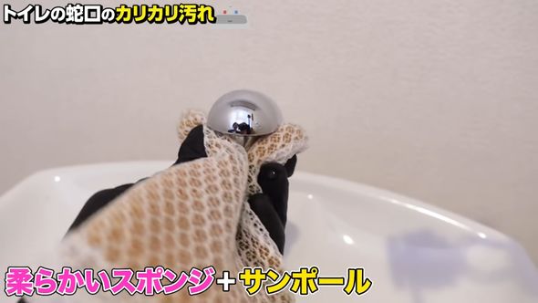 蛇口のカルキ汚れを落とすため酸性のトイレ用洗剤が付いたスポンジでこする
