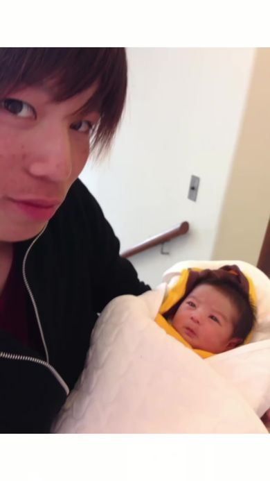 生まれたばかりの娘を抱っこしている父
