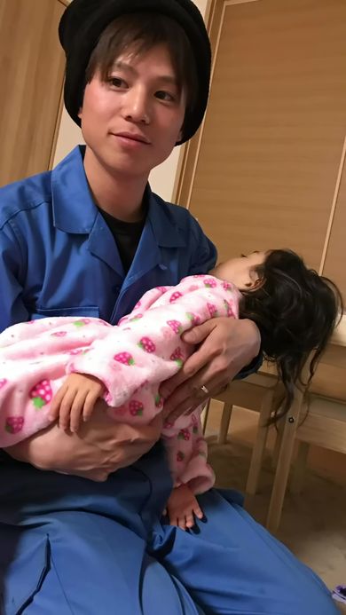 寝てしまった娘をほほ笑みながら抱っこする父
