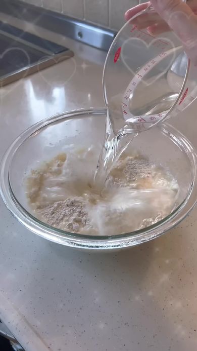 ラーメンを作るため粉に水を加える男子高校生