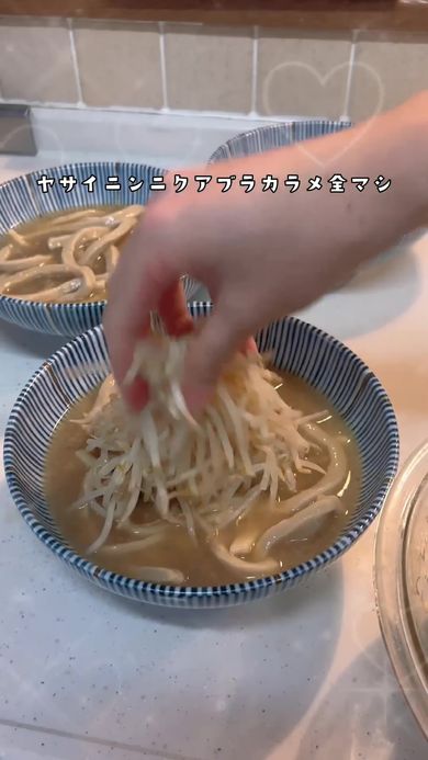 丼に麺や大量のもやしを盛り付ける男子高校生