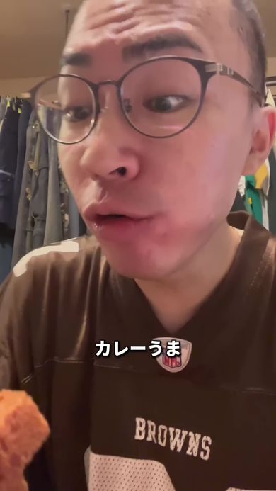 帰宅後にすっぴんの状態で買ってきた揚げカレーパンを堪能する丸刈り頭の男性