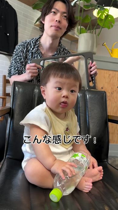 美容師のパパに鏡で後頭部の仕上がりを見せてもらう赤ちゃん