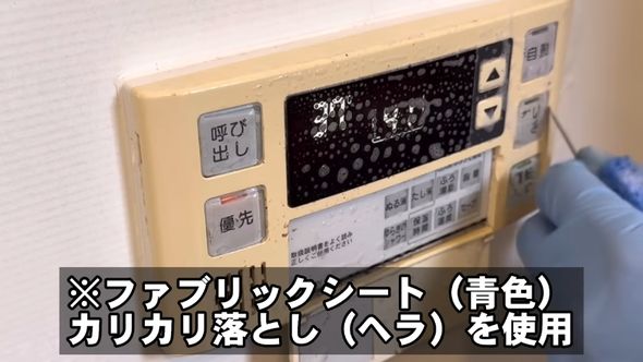 2倍に薄めた業務用洗浄剤を使い給湯パネルの汚れを布シートとヘラで落としていく