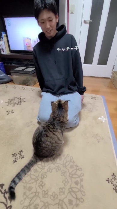 ニャンコと向き合う男性