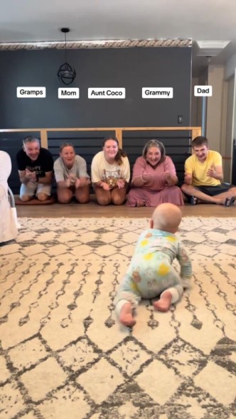 家族に呼ばれてハイハイする赤ちゃん