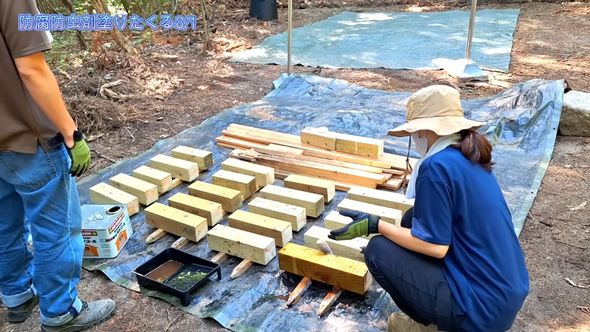 夫婦2人で暮らすための小屋をDIYで作るため束柱に防腐剤を塗る