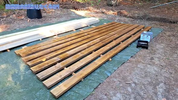 夫婦2人で暮らすための小屋をDIYで作るため長尺木材に防腐剤を塗る
