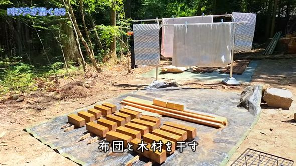 夫婦2人で暮らすための小屋をDIYで作るため布団と一緒に木材を干す