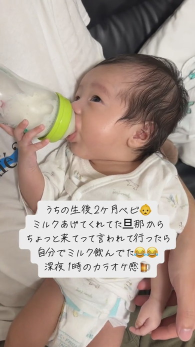 自分で哺乳瓶を持ってミルクを飲む赤ちゃん