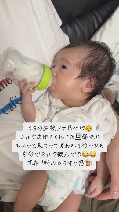 自分で哺乳瓶を持ってミルクを飲む赤ちゃん