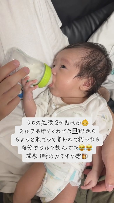自分で哺乳瓶を持ってミルクを飲む赤ちゃん