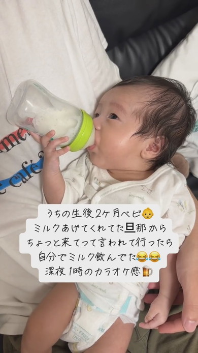 自分で哺乳瓶を持ってミルクを飲む赤ちゃん