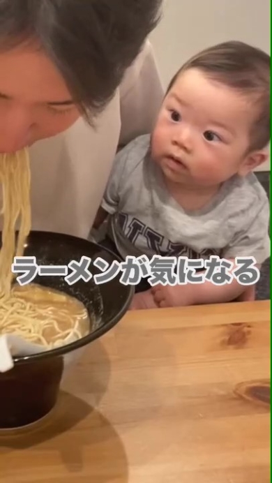 ラーメンを食べるパパを見つめる赤ちゃん