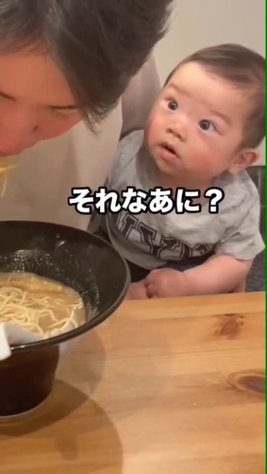 ラーメンを食べるパパを見つめる赤ちゃん