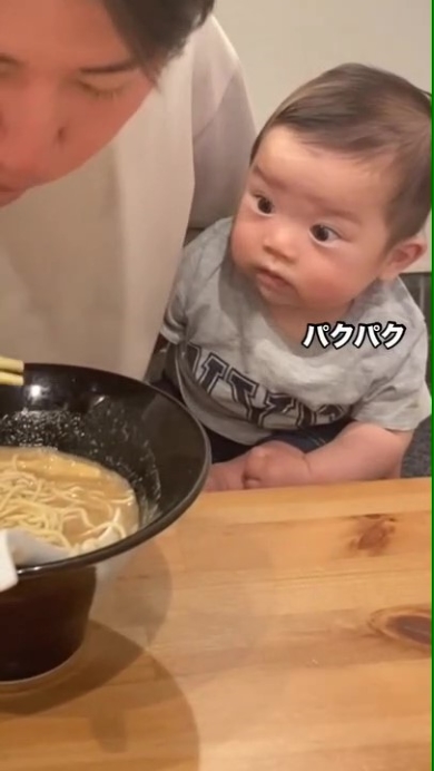 ラーメンを食べるパパを見つめる赤ちゃん