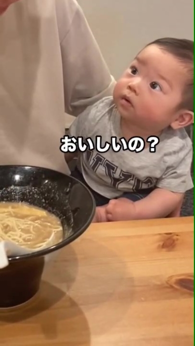 ラーメンを食べるパパを見つめる赤ちゃん