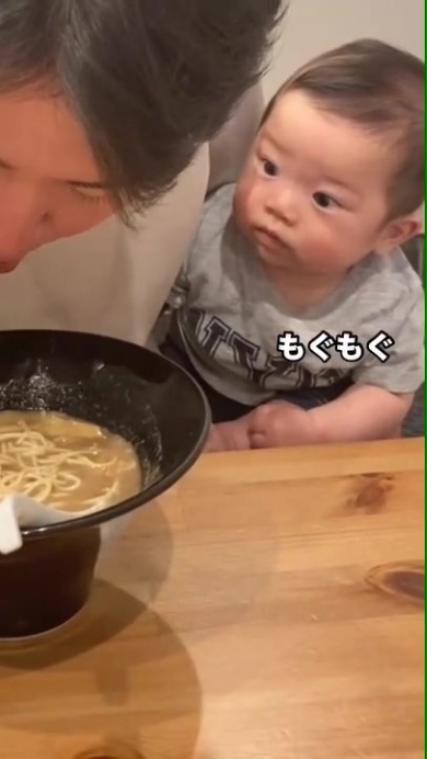 ラーメンを食べるパパを見つめる赤ちゃん