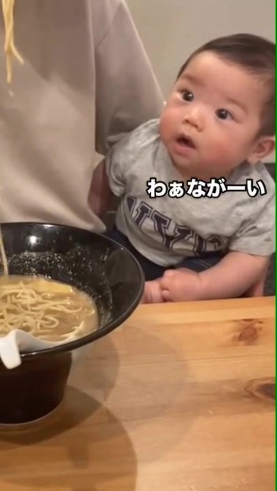 ラーメンを食べるパパを見つめる赤ちゃん