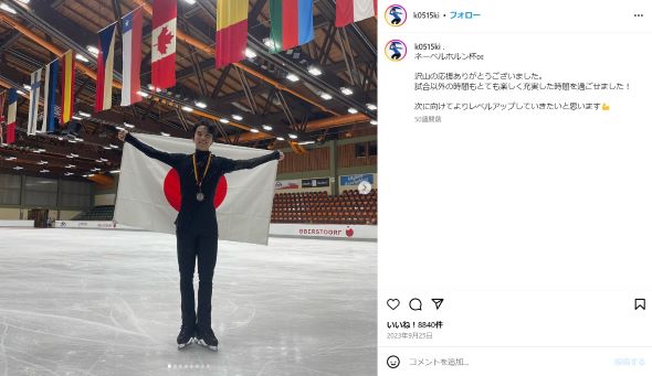 スケートリンクで日の丸の旗を背中に持った友野選手