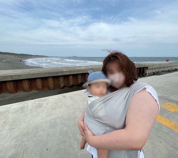 海を背景に記念撮影をするママと赤ちゃん