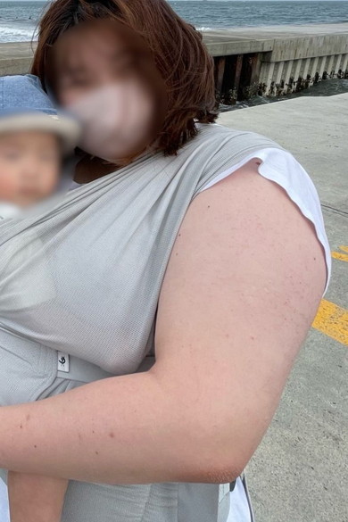 海を背景に記念撮影をするママと赤ちゃん