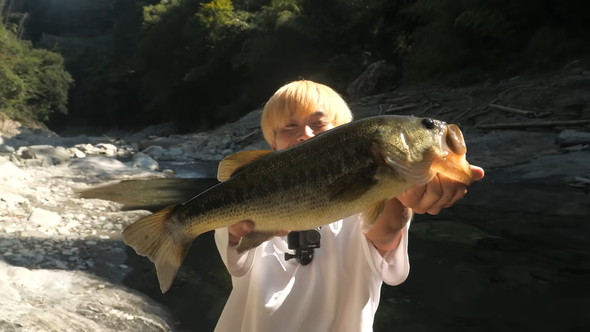 ブラックバスを釣り上げた男性