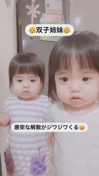 並んでカメラを見ている1歳の双子の姉妹