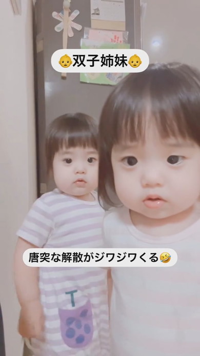 並んでカメラを見ている1歳の双子の姉妹