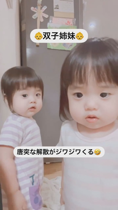 並んでカメラを見ている1歳の双子の姉妹
