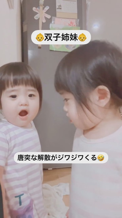 並んでカメラを見ている1歳の双子の姉妹