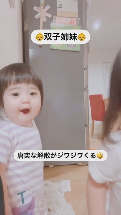 並んでカメラを見ている1歳の双子の姉妹