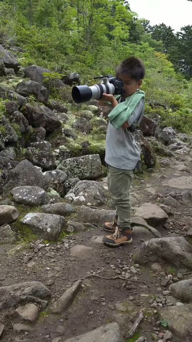 ナキウサギを撮影するためカメラを構える9歳のカメラマン